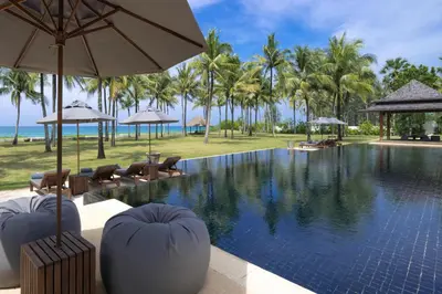a pool at a resort with chairs and umbrellas at Villa Ananda at Jivana Beach Villas in Pilai Beach