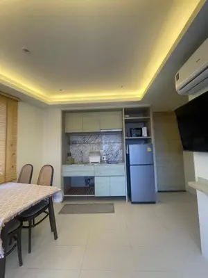 a kitchen with a table and a blue refrigerator at Cozy corner in Ao Nang Beach