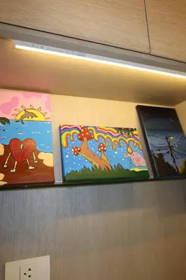 a shelf with three paintings on a wall at Cozy corner in Ao Nang Beach