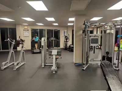 a gym with machines and a woman in the background at Veloche Karon 12 in Karon Beach