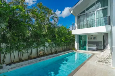 a swimming pool in front of a house with palm trees at Spacious 4BR Pool Villa at Grand View in Bangtao in Bang Tao Beach