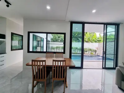 a dining room with a wooden table and chairs at Sanook villas Nai Harn beach in Rawai Beach