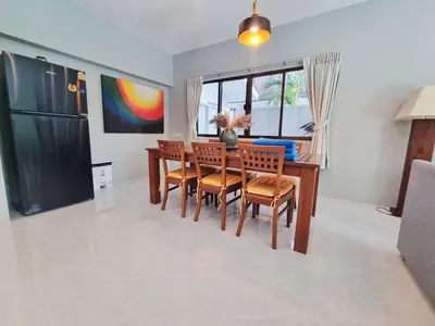 a dining room with a wooden table and chairs at Sanook villas Nai Harn beach in Rawai Beach