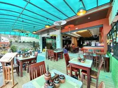 a restaurant with wooden tables and chairs and a blue ceiling at Lucky Residence Patong in Patong Beach