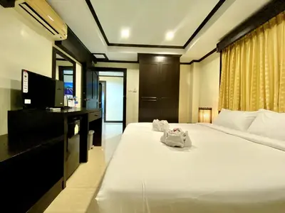 a bedroom with a large bed with a tv and a bedzinski at Lucky Residence Patong in Patong Beach
