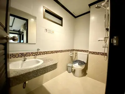 a bathroom with a sink and a toilet and a mirror at Lucky Residence Patong in Patong Beach