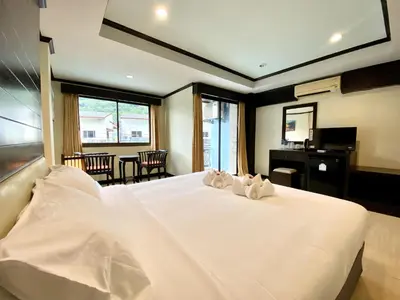 a bedroom with a large white bed with two pillows on it at Lucky Residence Patong in Patong Beach