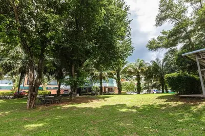 a park with trees and benches and a building at Cosy 1 bedroom Chic condo in Karon Beach