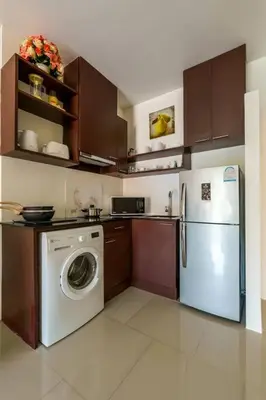 a kitchen with a refrigerator and a washing machine at Cosy 1 bedroom Chic condo in Karon Beach