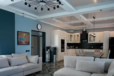a living room with white couches and a kitchen at Phuket Villa Sofia in Ban Phak Chit