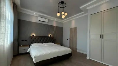 a bedroom with a large bed and a chandelier at Phuket Villa Sofia in Ban Phak Chit