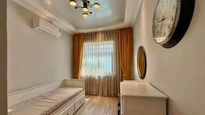 a living room with a large clock on the wall at Phuket Villa Sofia in Ban Phak Chit