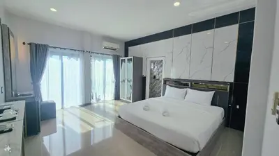 a bedroom with a white bed and a large window at Smile Boutique at Saiyuan in Rawai Beach