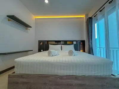 a bedroom with a large white bed with two pillows at Smile Boutique at Saiyuan in Rawai Beach