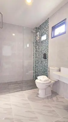 a bathroom with a toilet and a glass shower at Smile Boutique at Saiyuan in Rawai Beach