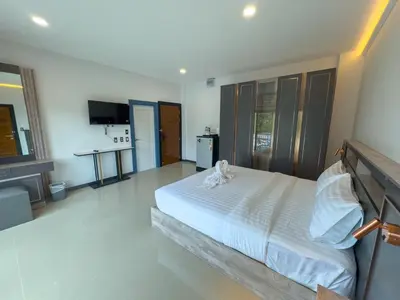 a bedroom with a large bed with white sheets at Smile Boutique at Saiyuan in Rawai Beach