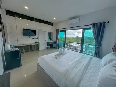 a bedroom with a bed with a cat sitting on it at Smile Boutique at Saiyuan in Rawai Beach