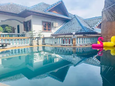 a swimming pool with a pink swan in front of a house at Phuket Patong Plan B house in Patong Beach