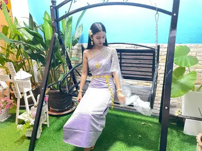 a woman in a dress standing on a swing at Phuket Patong Plan B house in Patong Beach