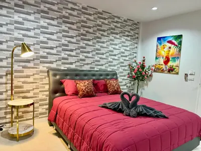 a bedroom with a red bed with a brick wall at TN KAMALA Room For Rent in Kamala Beach