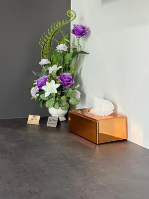 a vase of purple and white flowers sitting next to a box at TN KAMALA Room For Rent in Kamala Beach