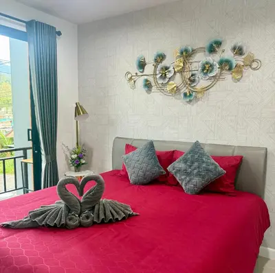 a bedroom with a red bed with a heart decoration on it at TN KAMALA Room For Rent in Kamala Beach
