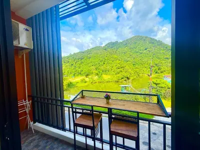 a balcony with a table and a view of a mountain at TN KAMALA Room For Rent in Kamala Beach