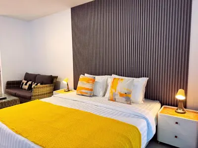 a bedroom with a large bed with a yellow blanket at Ground Floor Zen Space Kamala in Kamala Beach