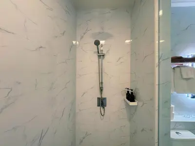 a shower in a bathroom with white marble walls at Ground Floor Zen Space Kamala in Kamala Beach