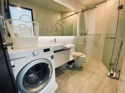 a washing machine in a bathroom with a shower at Oceana Kamala in Kamala Beach