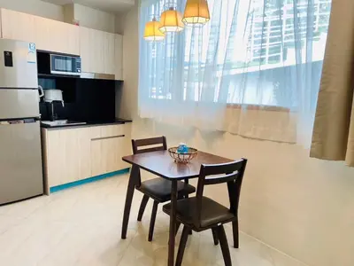 a kitchen with a table and two chairs and a refrigerator at Oceana Kamala in Kamala Beach