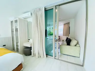 a bedroom with a bed and a sliding glass door at Oceana Kamala in Kamala Beach