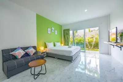a bedroom with a bed and a couch and a tv at Karon Hotel at 22 in Karon Beach