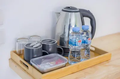 a wooden tray with water bottles and cups and a tea kettle at Karon Hotel at 22 in Karon Beach