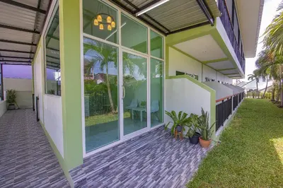a house with large glass doors and a patio at Karon Hotel at 22 in Karon Beach