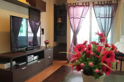a living room with a television and a vase of flowers at Nice Apartment large pool in nice residence central Patong beach in Patong Beach