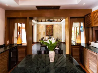 a kitchen with a table with a vase of flowers on it at Baan Surin Sawan in Surin Beach