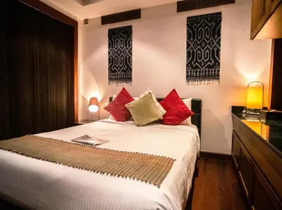 a bedroom with a large bed with red pillows at Baan Surin Sawan in Surin Beach