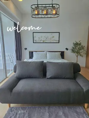a couch in front of a bed in a room at The Olive Studio Room at Chic Condominium in Karon Beach