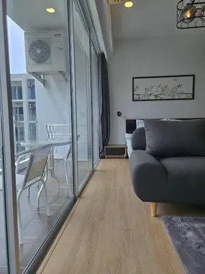 a living room with a couch and a table at The Olive Studio Room at Chic Condominium in Karon Beach