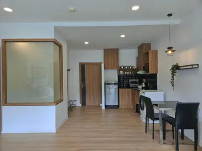 a living room and kitchen with a table and chairs at The Olive Studio Room at Chic Condominium in Karon Beach