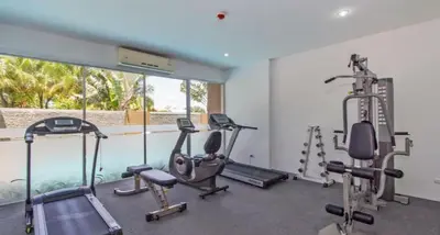 a gym with several tread machines and a window at The Olive Studio Room at Chic Condominium in Karon Beach
