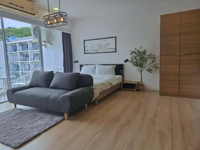 a bedroom with a bed and a couch in it at The Olive Studio Room at Chic Condominium in Karon Beach