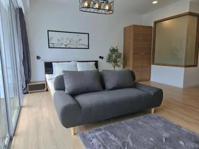 a living room with a couch and a bed at The Olive Studio Room at Chic Condominium in Karon Beach