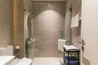 a bathroom with a shower with a glass door at Title Halo Life in Yellow 40m2 King Bed Pool in Nai Yang Beach