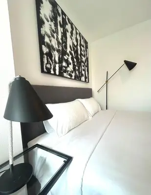 a bedroom with a white bed with a black lamp at Zcape 2 Boat Avenue, Laguna Brand New Renovated One bedroom Apartment with the Mountain View in Bang Tao Beach