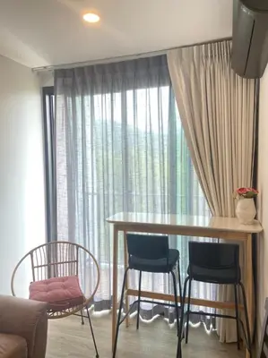 a living room with a table and chairs and a window at Zcape 2 Boat Avenue, Laguna Brand New Renovated One bedroom Apartment with the Mountain View in Bang Tao Beach