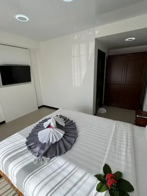 a large white bed with an umbrella on it at Apartment Mai Khao Beach in Mai Khao Beach