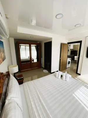 a bedroom with a large bed with white sheets and pillows at Apartment Mai Khao Beach in Mai Khao Beach