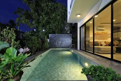 an infinity pool in the backyard of a house at night at 5 bdr Pool Villa Bang Tao Beach in Laguna Phuket